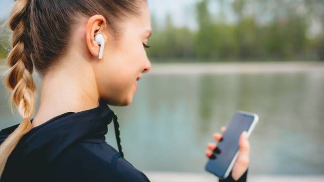 ワイヤレスイヤホンで音楽を聴く女性