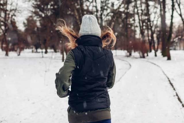冬の寒い中を走る女性